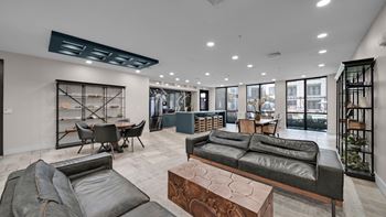 A modern living room with a black leather couch and a wooden coffee table.